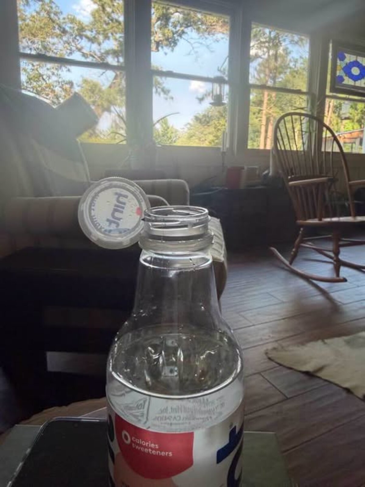 Pam Otts holding a stubborn new-style bottle cap that keeps smacking her nose — a lighthearted pet peeve shared from Dublin, GA